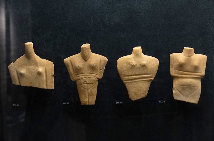 Fragments of Cycladic marble figurines displayed in museum cases at Museum of Cycladic Art in Athens.