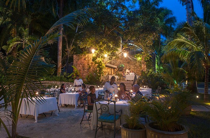 A group of persons having dinner at Half Moon Jamaica and a few waiters attending to the guests