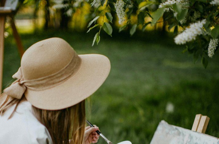A person participating in a painting class at the garden with one-on-one guidance from the artist.