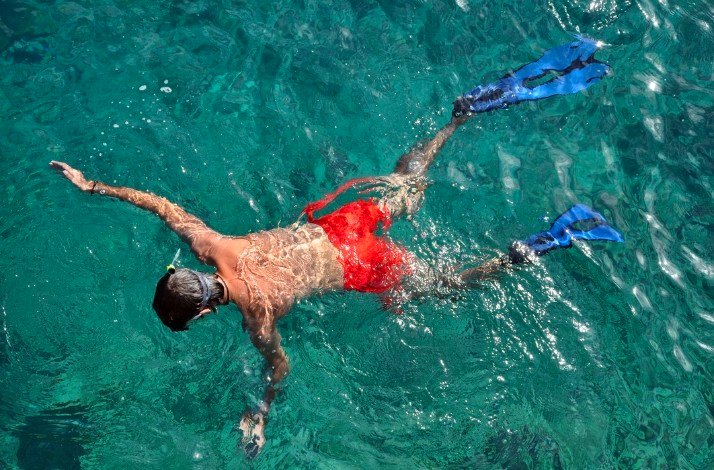 A person doing snorkel in crystal water