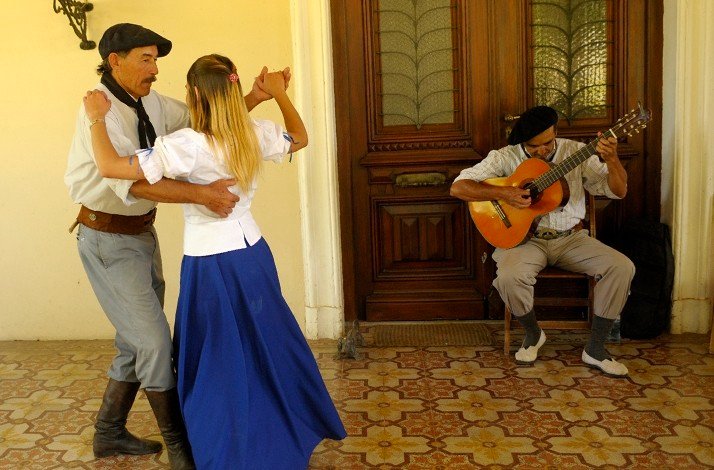 A couple engaged in a joyful folk dance accompanied by the traditional music at the San Antonio de Areco, Argentina.