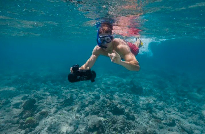 A man is filming underwater at Palm Beach, Aruba.
