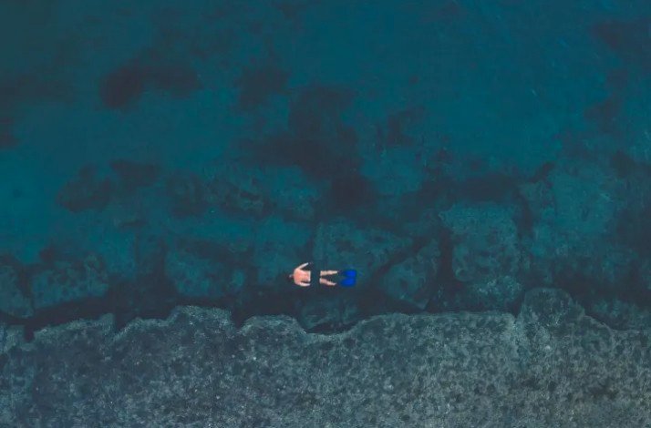A man is swimming in the ocean at Palm Beach, Aruba.