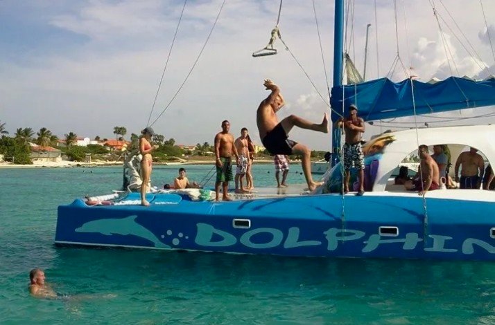 People jumping from a catamaran into the ocean at Palm Beach, Aruba.