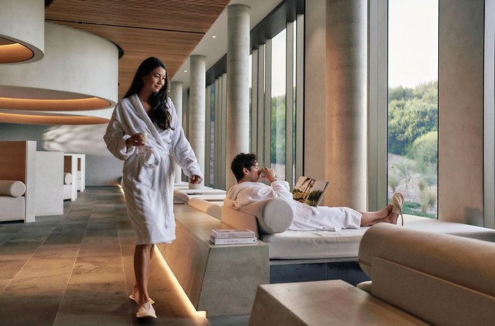 A woman and a man wearing robe and relaxing