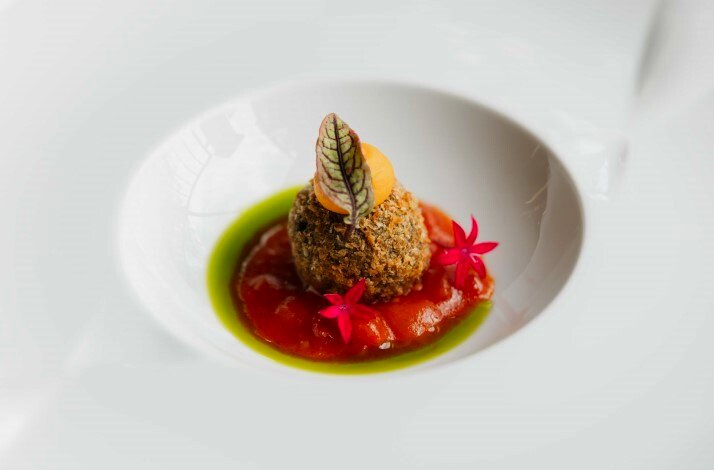 Dessert dish decorated with a leaf and flowers from the special menu at il Ponte restaurant.