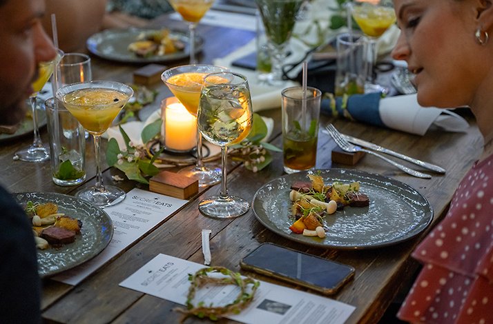 A close-up of a couple enjoying dinner and cocktails during an exclusive SecretEATS mystery dinner at a surprise venue in Johannesburg.