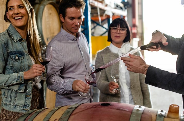 People testing a wine right from the barrel