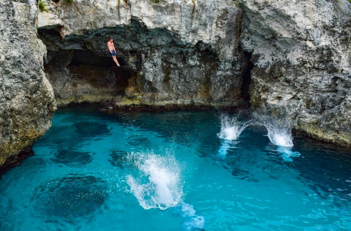 Tourists jumping into the Blue Hole swimming cave, Jamaica.