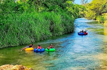 Group of tourists on a river-tubing tour of Jamaica's famous Rio Bueno