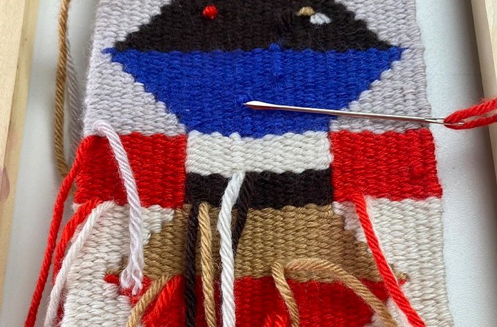 Close shot from a garment from a loom with a knitting needle