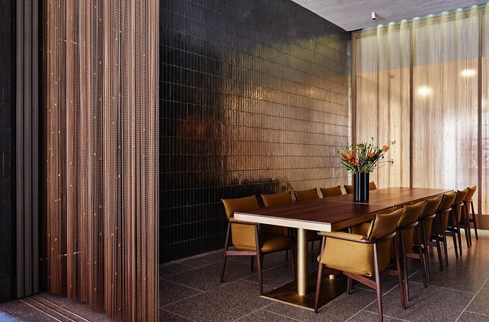 Elegant private dining room with a long table, upholstered chairs, and soft light filtering through sheer curtains. At the New York Philharmonic.