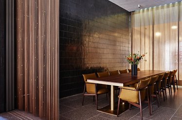 Elegant private dining room with a long table, upholstered chairs, and soft light filtering through sheer curtains. At the New York Philharmonic.