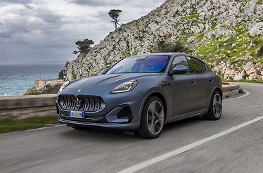 The exterior of Maserati Grecale Folgore Bianco Astro driving  through the countryside