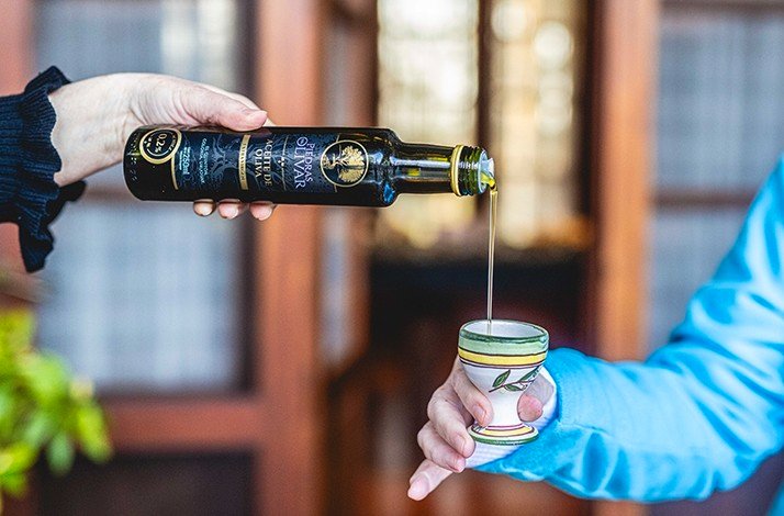 A close shot of olive oil being poured in a small tasting cup in  Viñedos y Olivares del Quintón