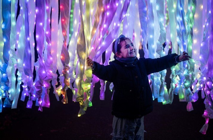 A child playing with Christmas light decorations at Kew Gardens