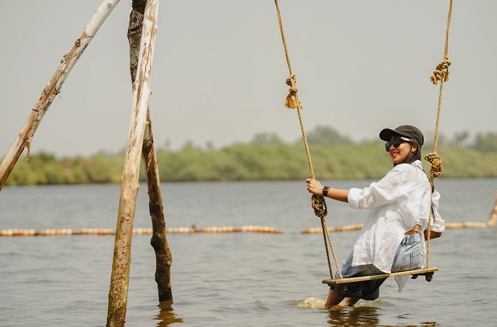 A girl on a swing at river Chaporá
