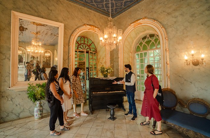 A group of people on a tour of Menezes Braganca House