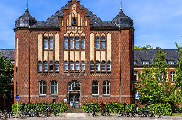 Historic brick building of Berliner Medizinhistorisches Museum der Charité, surrounded by bicycles and greenery.