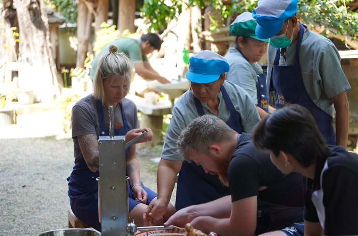A group of persons working on a workshop with Chiang Mai villagers