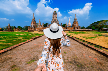 A person heading towards Wat Chaiwatthanaram Buddhist temple Ayutthaya, Thailand.