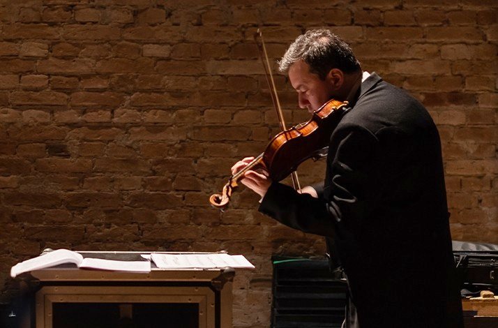 A person playing violin on stage of  Theatro Municipal