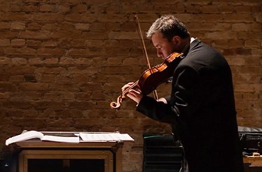 A person playing violin on stage of  Theatro Municipal