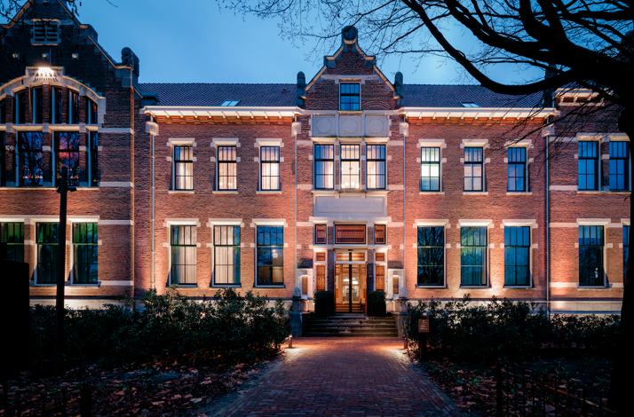Pillows Maurits at the Park hotel facade lit up at night in Amsterdam.