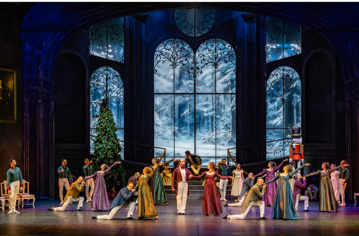 Ensemble of ballet dancers performing on a festive stage..