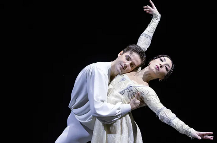 Two dancers portraying Romeo and Juliet against a black background
