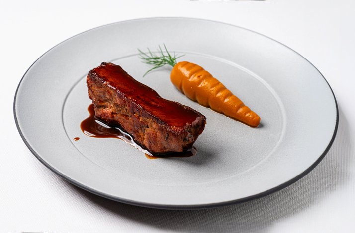 Glazed meat cut with rich dark sauce and a whole glazed carrot topped with dill, plated minimalist-style at Ristorante Trequarti.