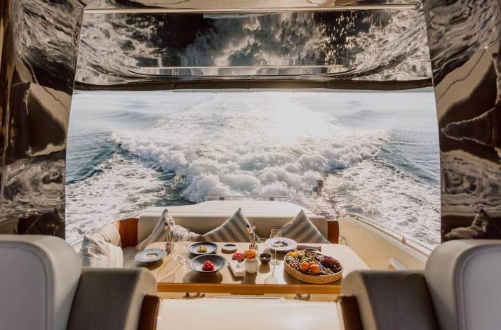 Table full of variety of dishes and the view on the water.