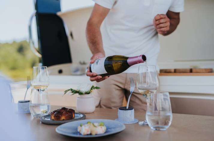 A man pouring the wine into the glass.