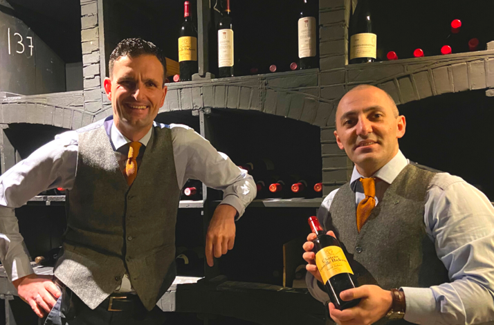 Two employees of Landgoed Lauswolt showing the wine served at the estate.