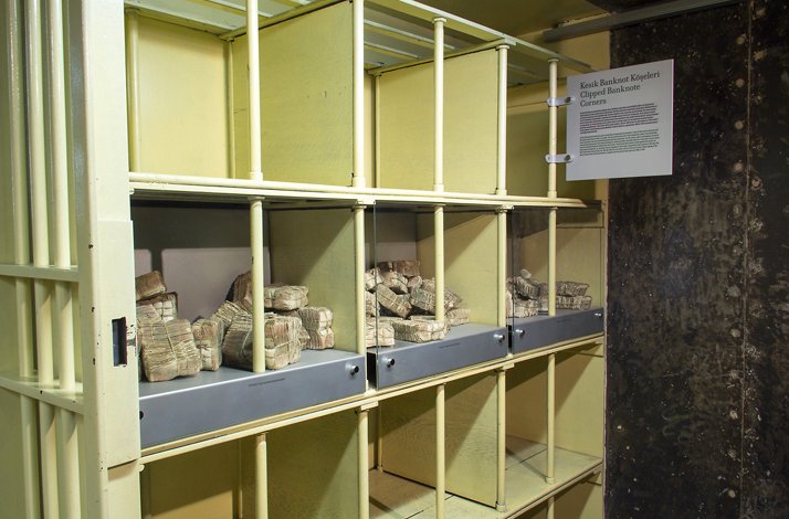 Shelves with glass enclosures holding bundles of clipped, old banknotes in the museum.