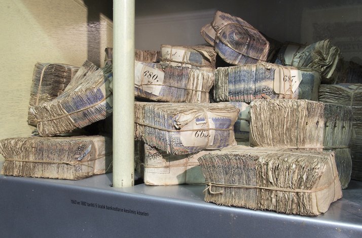 Close-up of stacked, clipped bundles of historic banknotes tied with string.