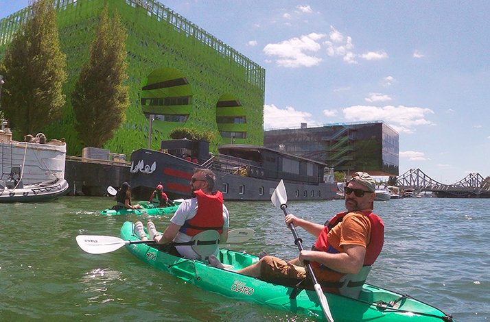 A group of tourists participating in kayaking tour in Lyon near the Green Cube building