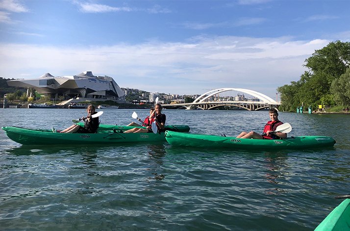 A group of tourists participating in kayaking tour in Lyon near the Musée des Confluences