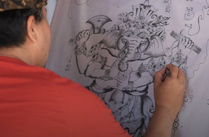 Balinese artist drawing Ganesha, the elephant god, Bali, Indonesia.