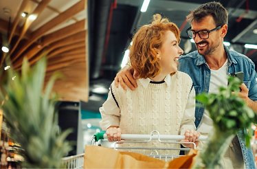 A couple at the shopping mall buying fruits together 
