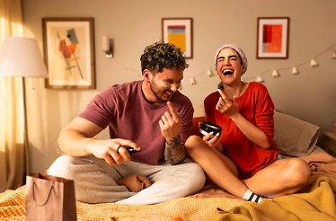 A couple laughing together with a skin care product