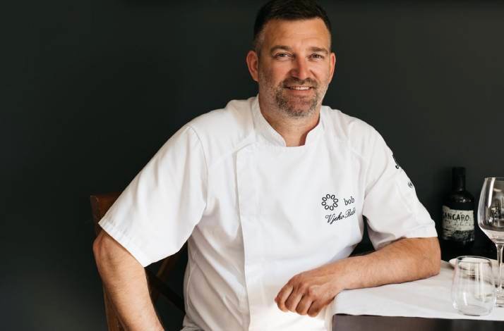 A chef smiling to the camera and posing