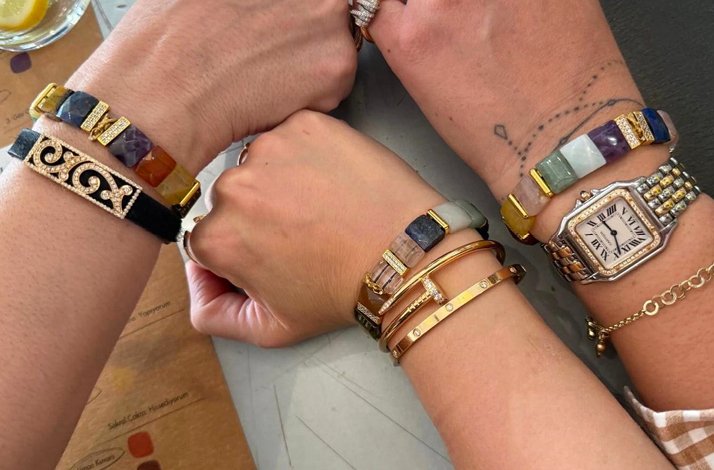 Three hands wearing one-of-a-kind natural stone bracelets made in Bebek Showroom during the workshop by Pia Yuli's founder, Pınar Yürekli.
