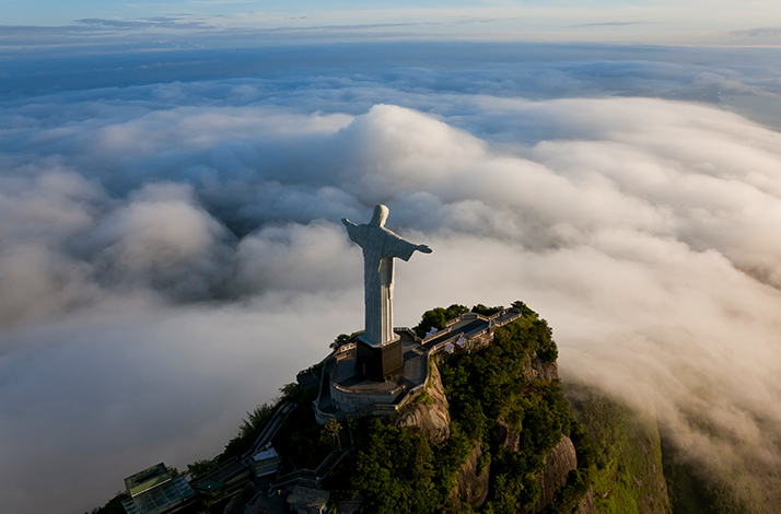 Bird view on the Christ the Redeemer, statue of Jesus overlooking clouds.