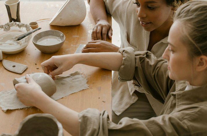 Two women working with their hands on a ceramics class.