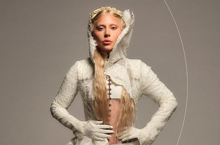 Lady Gaga in a white ball costume and gloves.