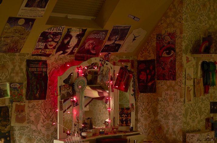 Shroud yourself in gothic mystery at Viola's Room at The Shed: In New York, New York A bedroom dressing table with a mirror and items, with posters on the walls.