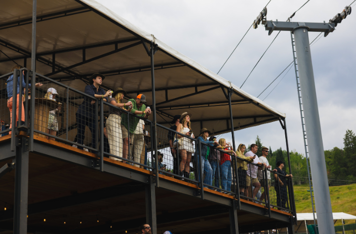 Several spectators on the private Mastercard Cabin with elevated views of the stage at Up in the Sky Festival.