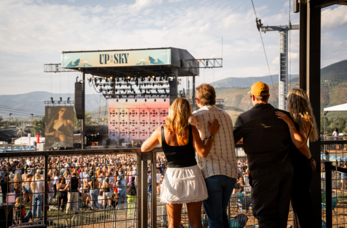 Several spectators on the private Mastercard Cabin with elevated views of the stage at Up in the Sky Festival.