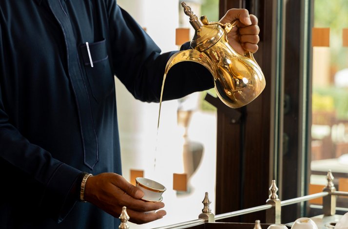 Waiter pouring tea into a cup at Maiz AlKhozama Saudi Fine Dining Restaurant 